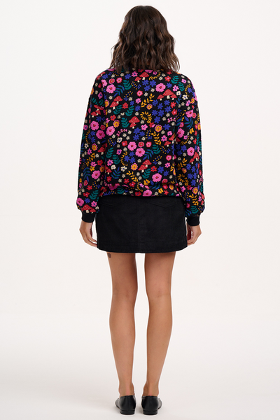 Model i sweatshirt med farverigt print – set bagfra, viser ryg og pasform.