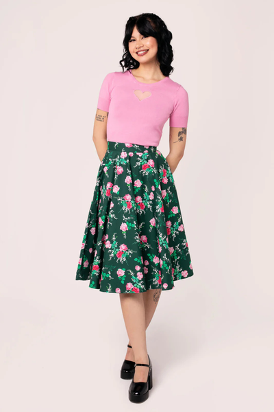 Model iført Hell Bunny Mabel Skirt – grøn vintage cirkelskørt med pink og røde roser, 50’er inspireret look