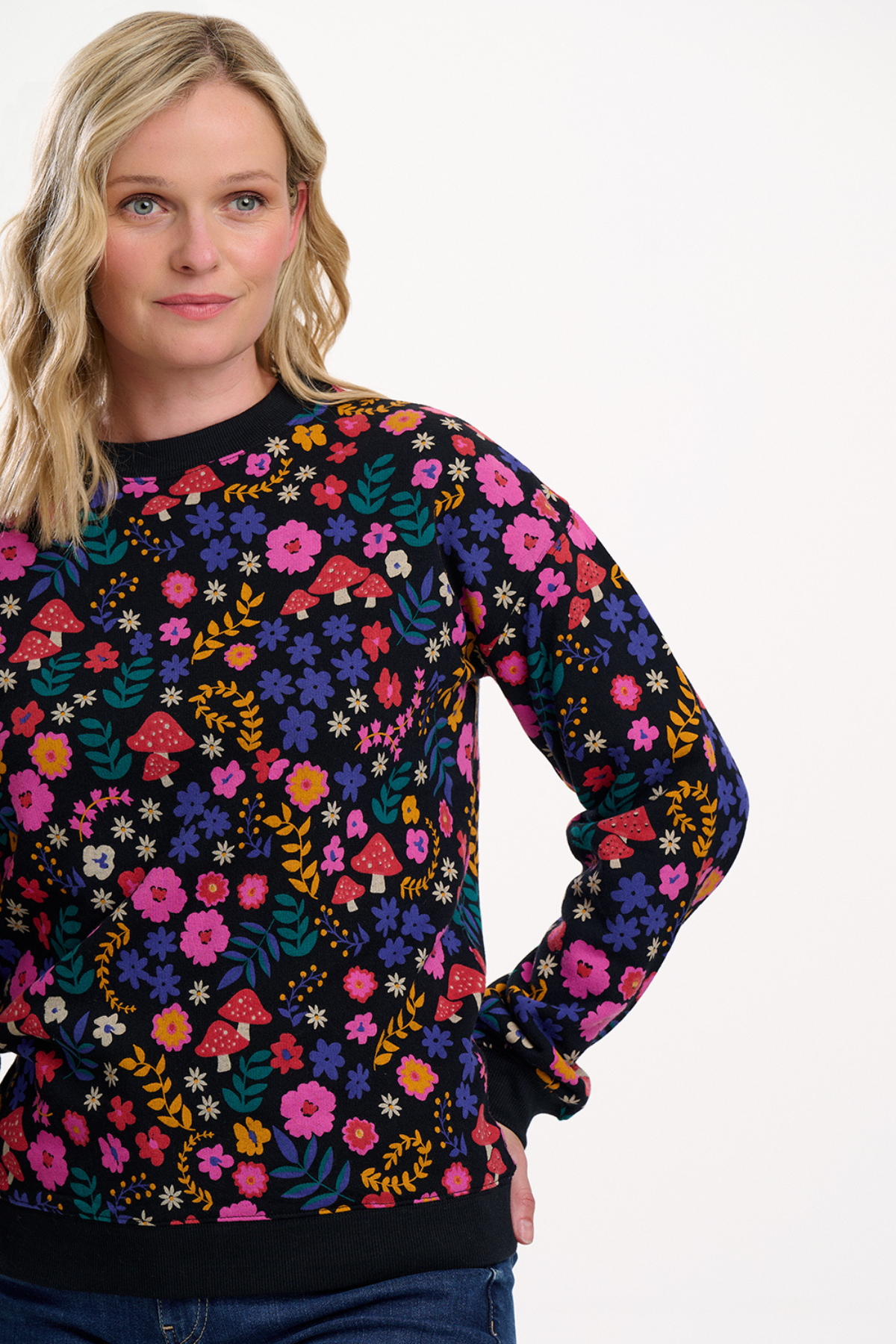 Blond model i farverig printet sweatshirt – set fra siden med fokus på pasform og mønsterdetaljer.