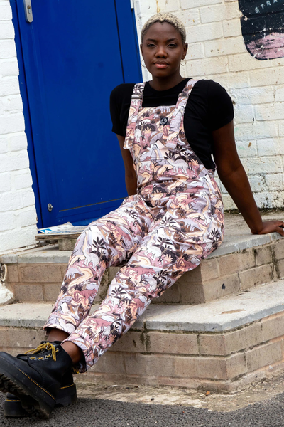 Rebel Romance Dinoverse Stretch Dungarees vist fra siden, med fokus på farverigt dino-print og behagelig unisex pasform.