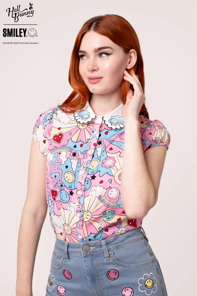 Rød model i Loulou Blouse med hånd på kinden – detaljeret print ses tydeligt.