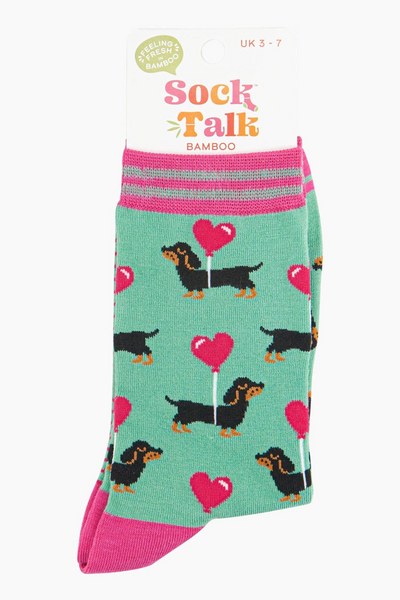 Mintgrønne bambusstrømper med ballon-hjerter og pølsehunde, vist i emballage fra Sock Talk