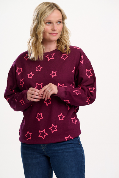 Model iført Eadie Relaxed Sweatshirt i Wine farve med pink stjerner – forfra.