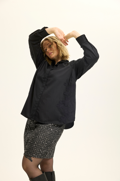 Model i sort pailletnederdel fra Anyday Curves stylet med skjorte.