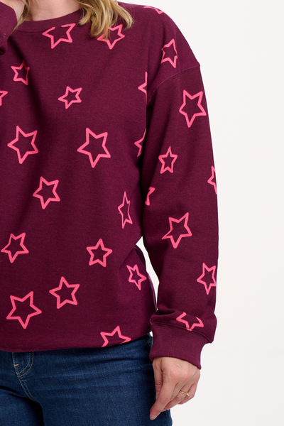 Nærbillede af Eadie Sweatshirt med pink stjerneprint på Burgundy baggrund.