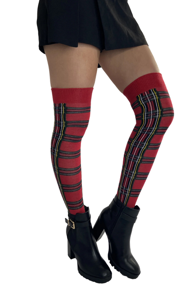 Model viser Pamela Mann Tartan Over The Knee Socks i rød tartan med sort, gul og grønne detaljer, stylet med sorte støvler.
