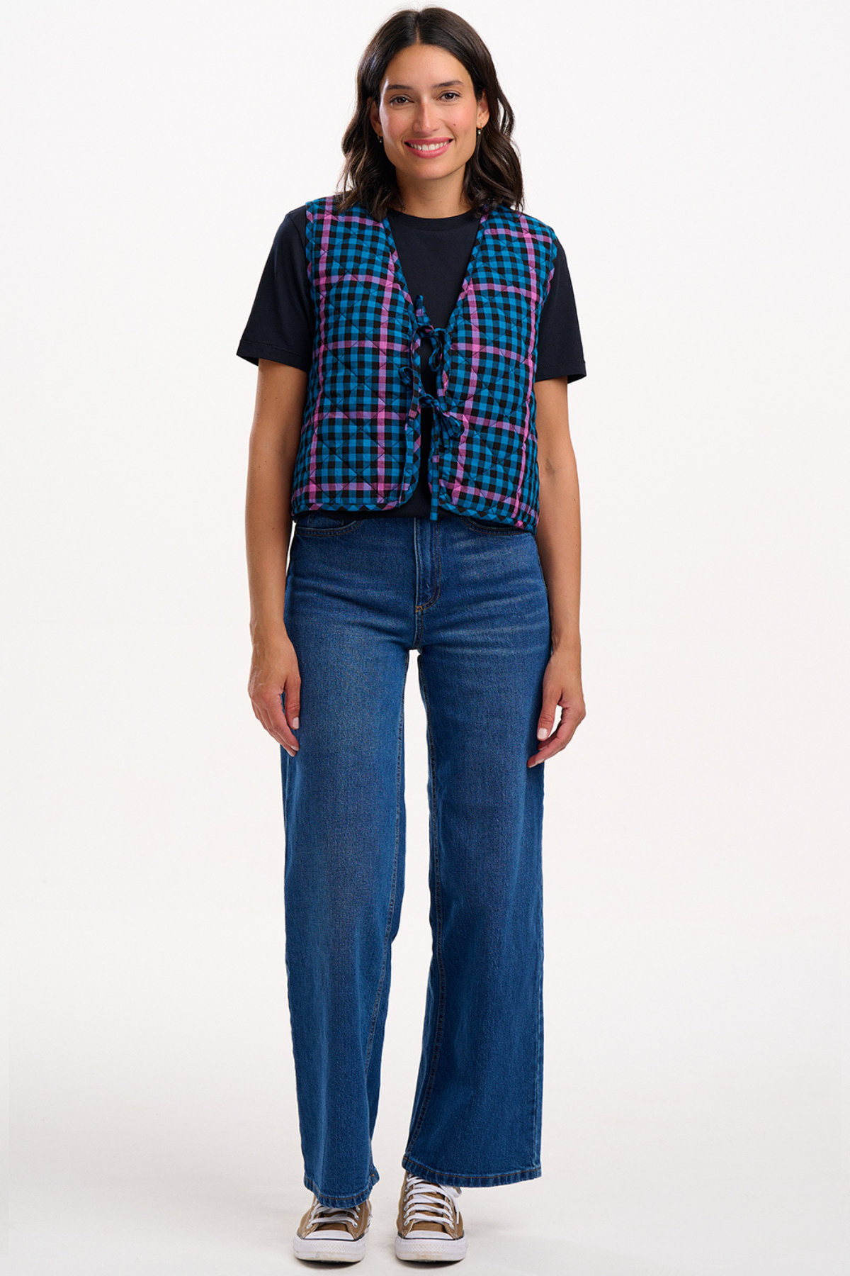 Vesten stylet over sort T-shirt og jeans, quiltet struktur