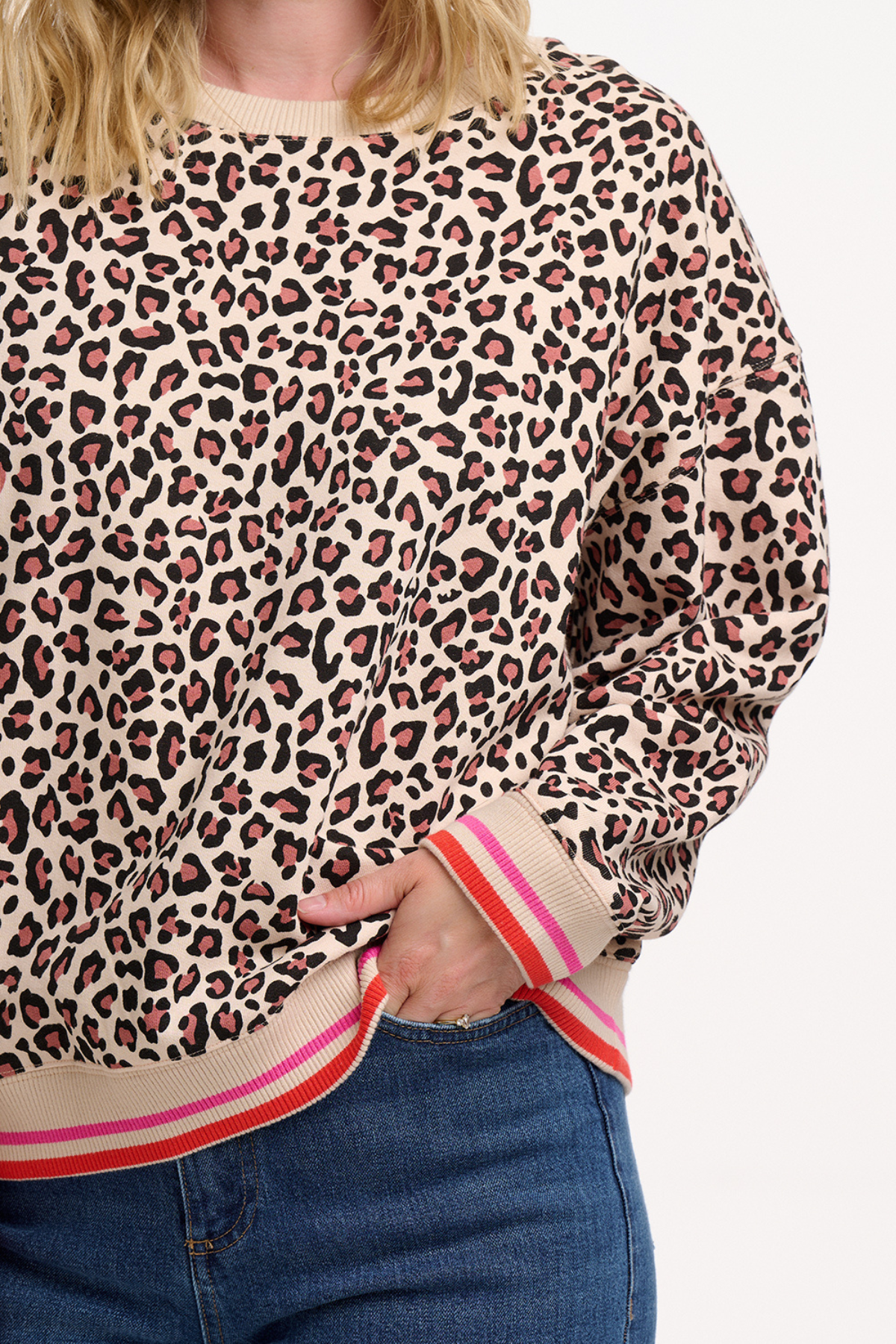 Close-up af Eadie Sweatshirt med leopardprint og sporty ribdetaljer i pink og rød.