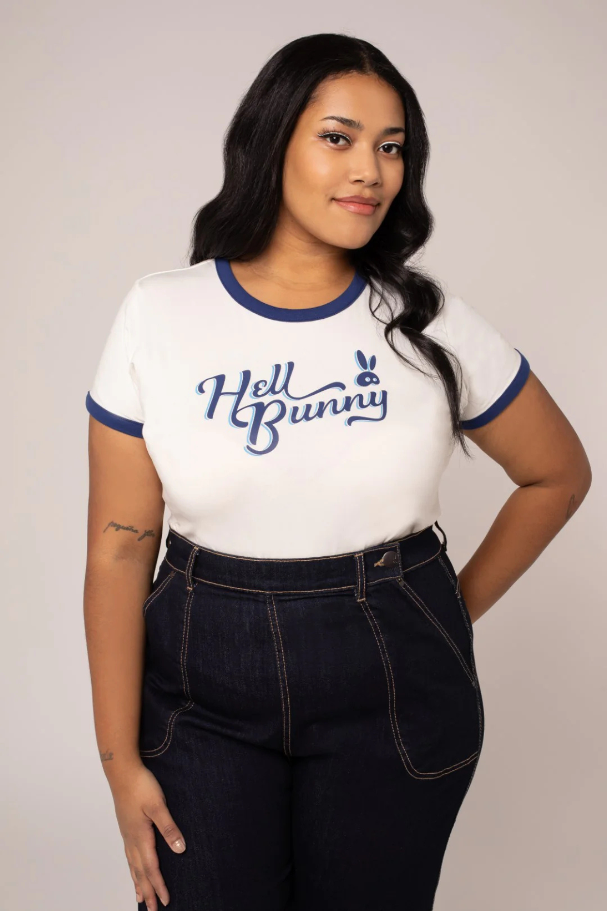 Kurvet model iført Hell Bunny Lucy T-shirt i blå/hvid – frontvisning med hænderne bag ryggen