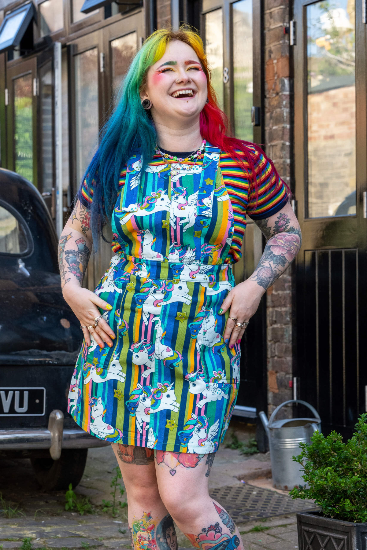 Model i RUN&FLY unicorn pinafore – smiler og viser fronten af kjolen