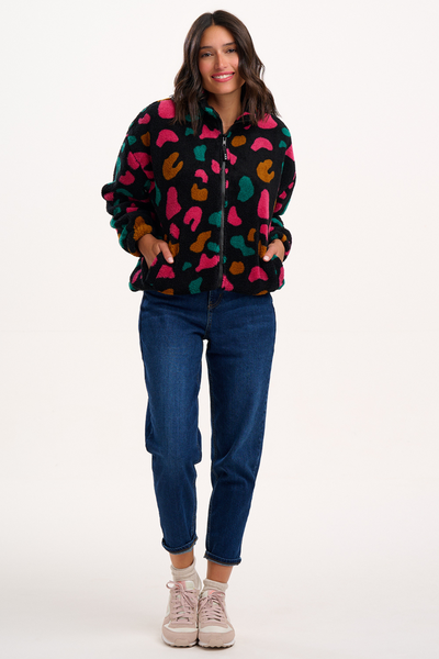 Model viser hele outfittet med fleecejakke, jeans og sneakers