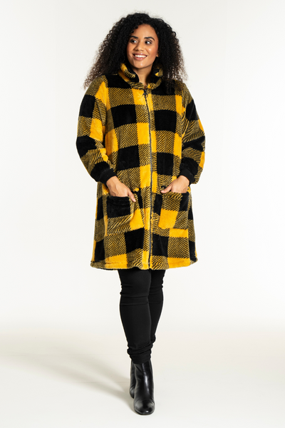 Studio Nellie Coat – ternet jakke med lynlås og høj krave, vist på model i sort outfit