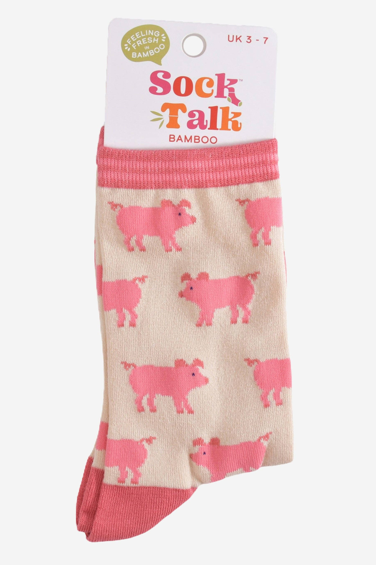 Produktvisning med emballage – sokkerne foldet med "Sock Talk Bamboo"-mærkat og grisemønster fremhævet