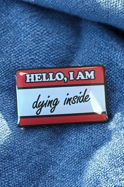 Pin fastgjort på blåt denimstof, set tæt på.