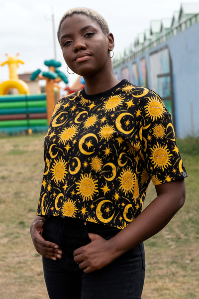 Model set fra siden i Rebel Romance Celestial Sun & Moon Tee, viser den boxy pasform og korte længde.