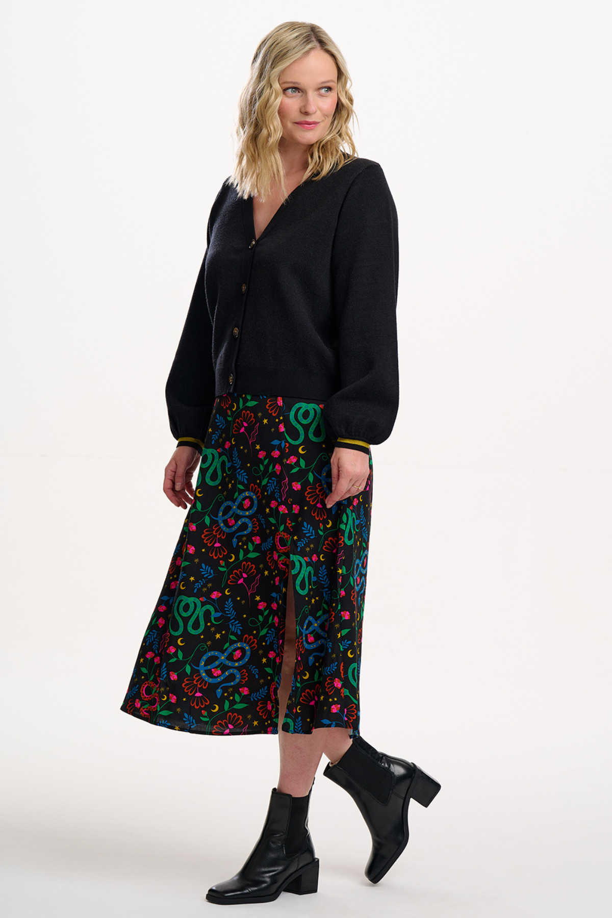 Model viser Rosalind Skirt i snake garden-print, stylet med sorte støvler