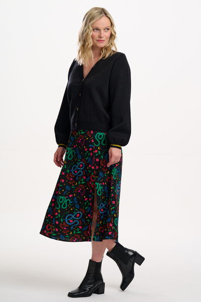 Model viser Rosalind Skirt i snake garden-print, stylet med sorte støvler