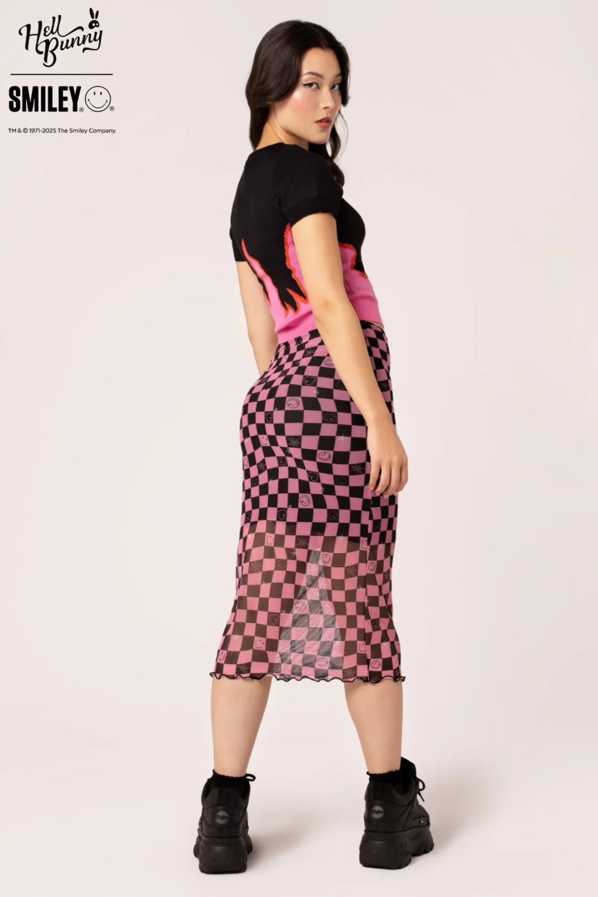 Bagside af Distortion Skirt, model vender sig let og viser nederdelens checkerboard print bagfra.