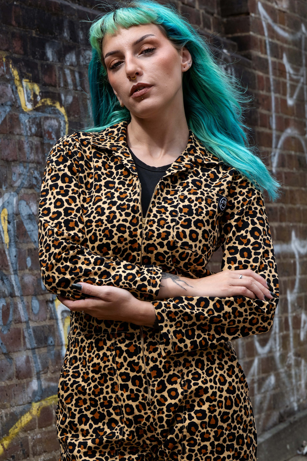 Rebel Romance Leopard Boiler Suit vist forfra – model med foldede arme og attitude.