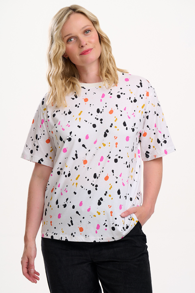 Model iført hvid Kinsley Relaxed T-shirt fra Sugarhill Brighton med farverigt splash-print i pink, orange, gul og sort.