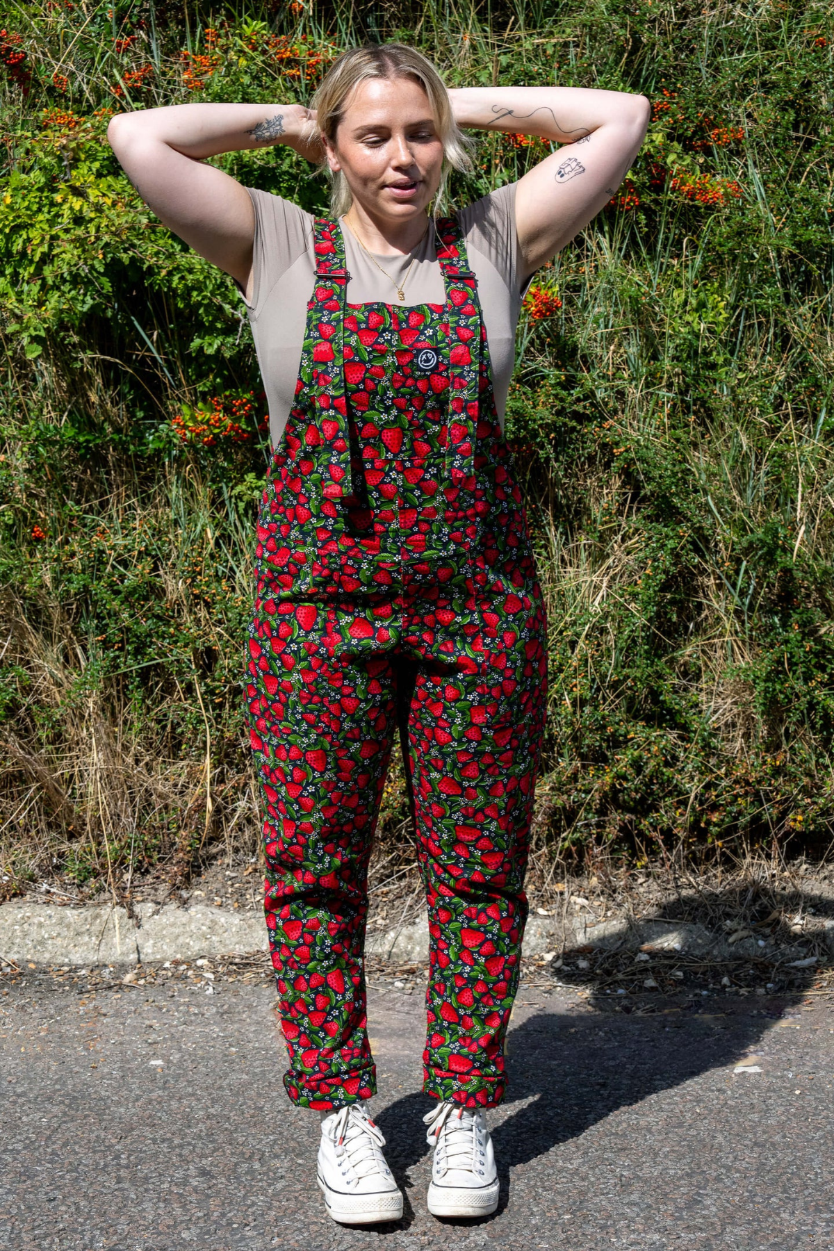Model i solskin med Strawberry Field dungarees – naturbaggrund
