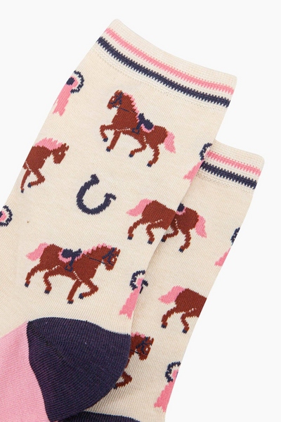 Detalje af beige bambusstrømper med heste og hestesko print.