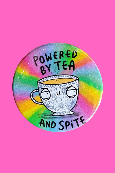Katie Abey badge med teksten Powered By Tea And Spite og tekop