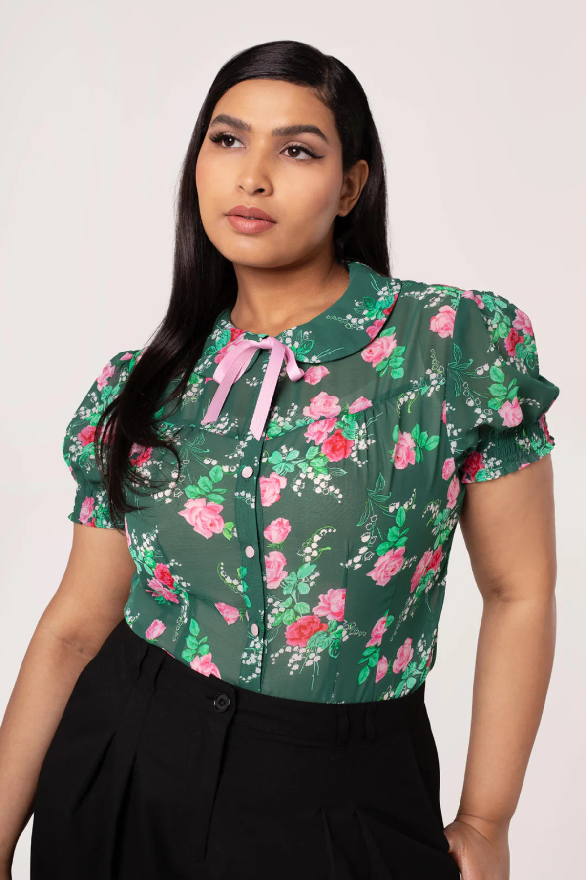 Plus size model iført Hell Bunny Mabel Skjorte – grøn chiffon skjorte med pink blomster og lyserød sløjfe i halsen