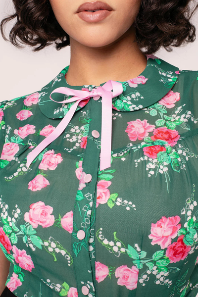 Nærbillede af Hell Bunny Mabel Skjorte – lyserød sløjfe, rosa knapper og smukt blomsterprint