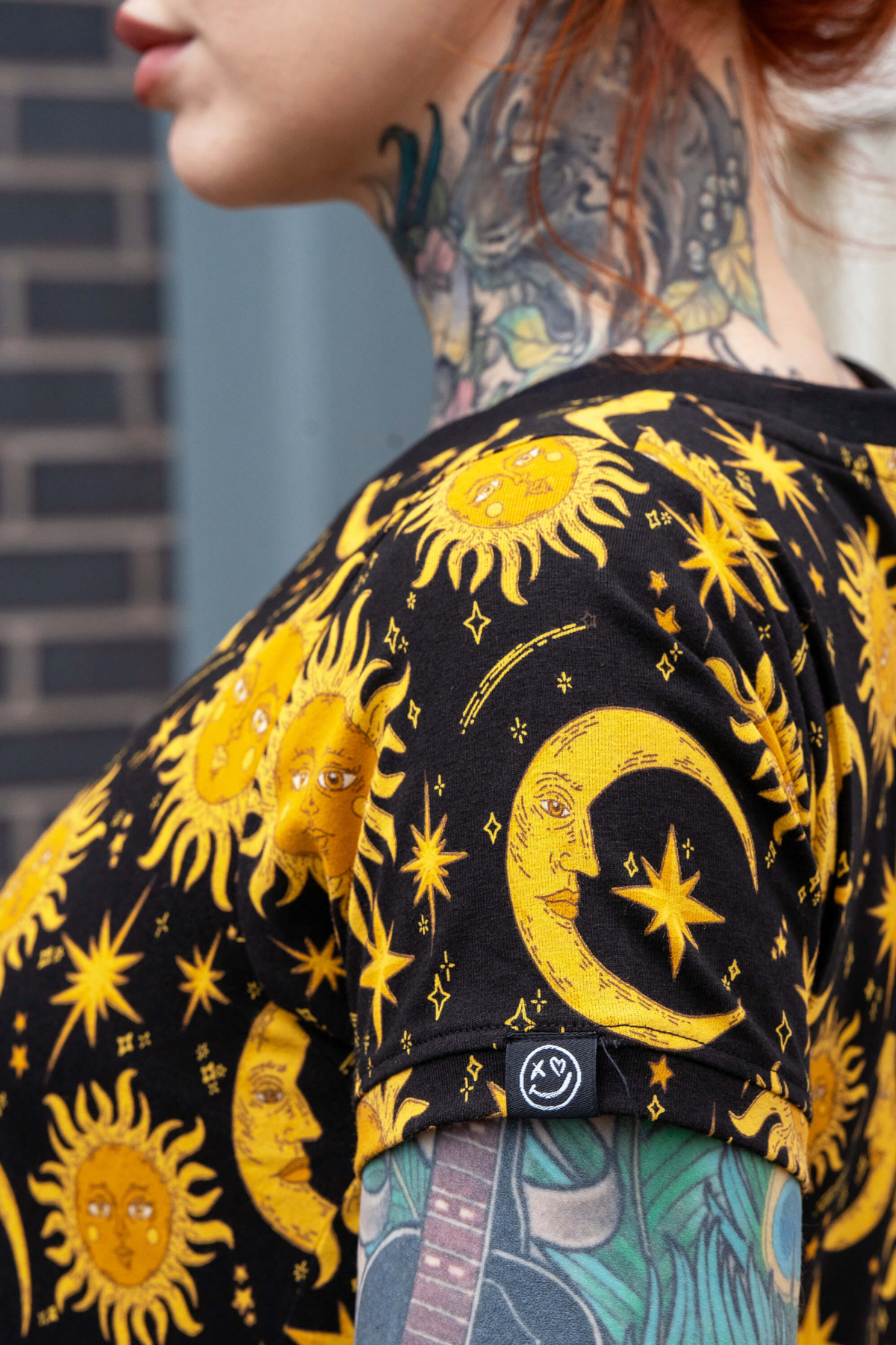 Ærmedetalje på Rebel Romance kjole – gul sol og måne print på sort baggrund.