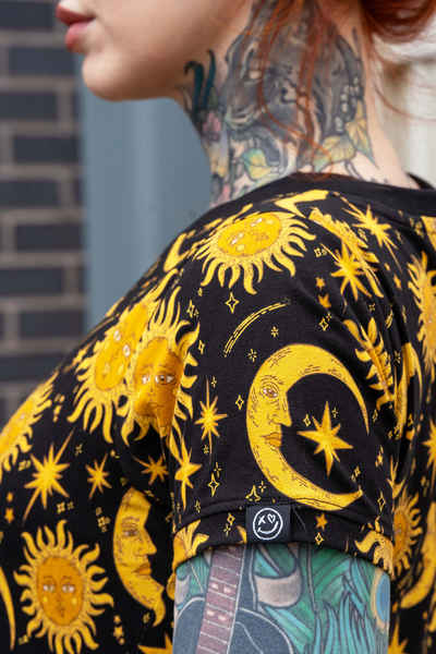 Ærmedetalje på Rebel Romance kjole – gul sol og måne print på sort baggrund.