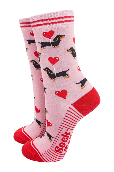 Lyserøde bambusstrømper fra Sock Talk med gravhunde og røde hjerteballoner – Dachshund Love model