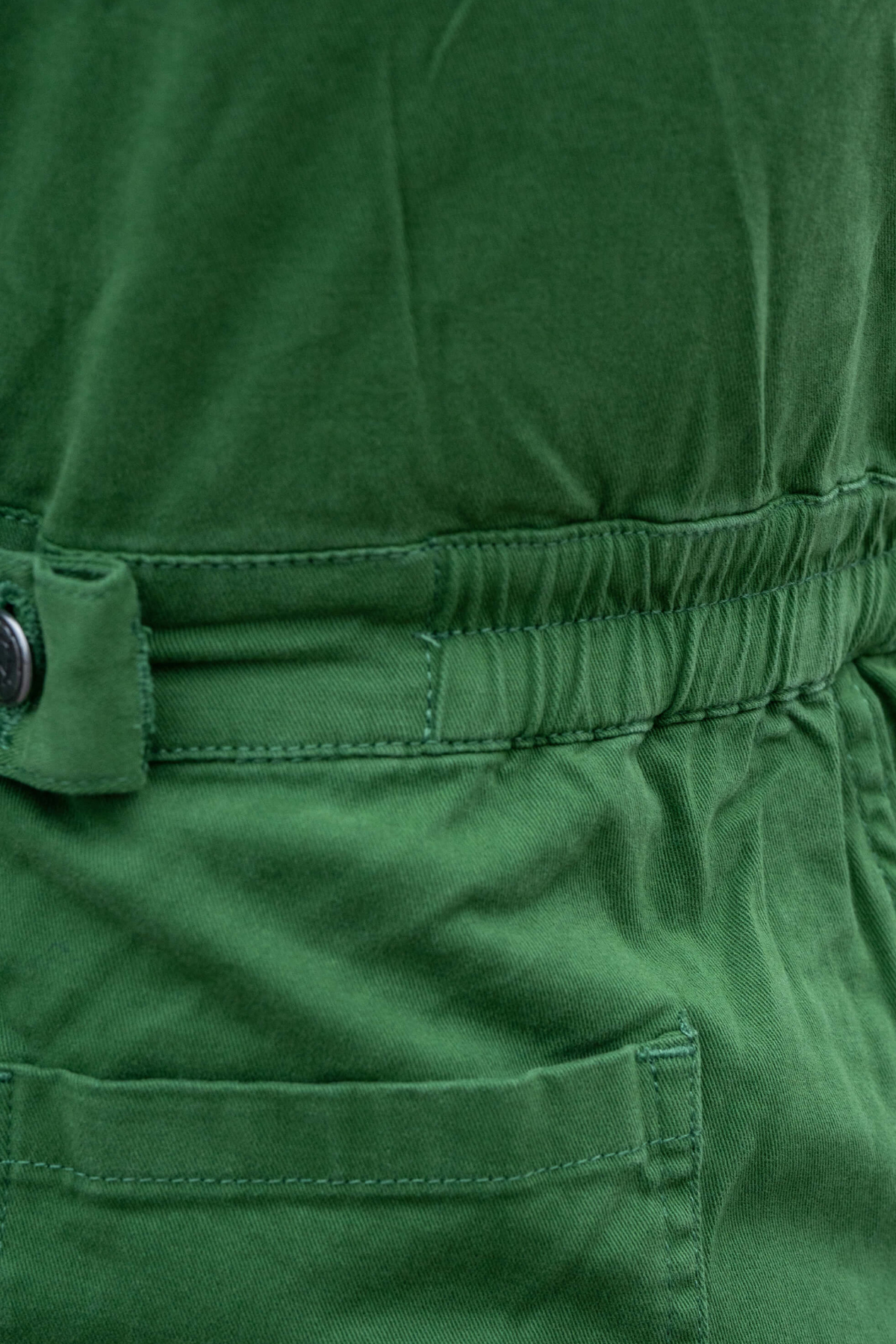 Detalje af elastisk talje og syninger bagpå Rebel Romance Forest Green Stretch Boiler Suit.