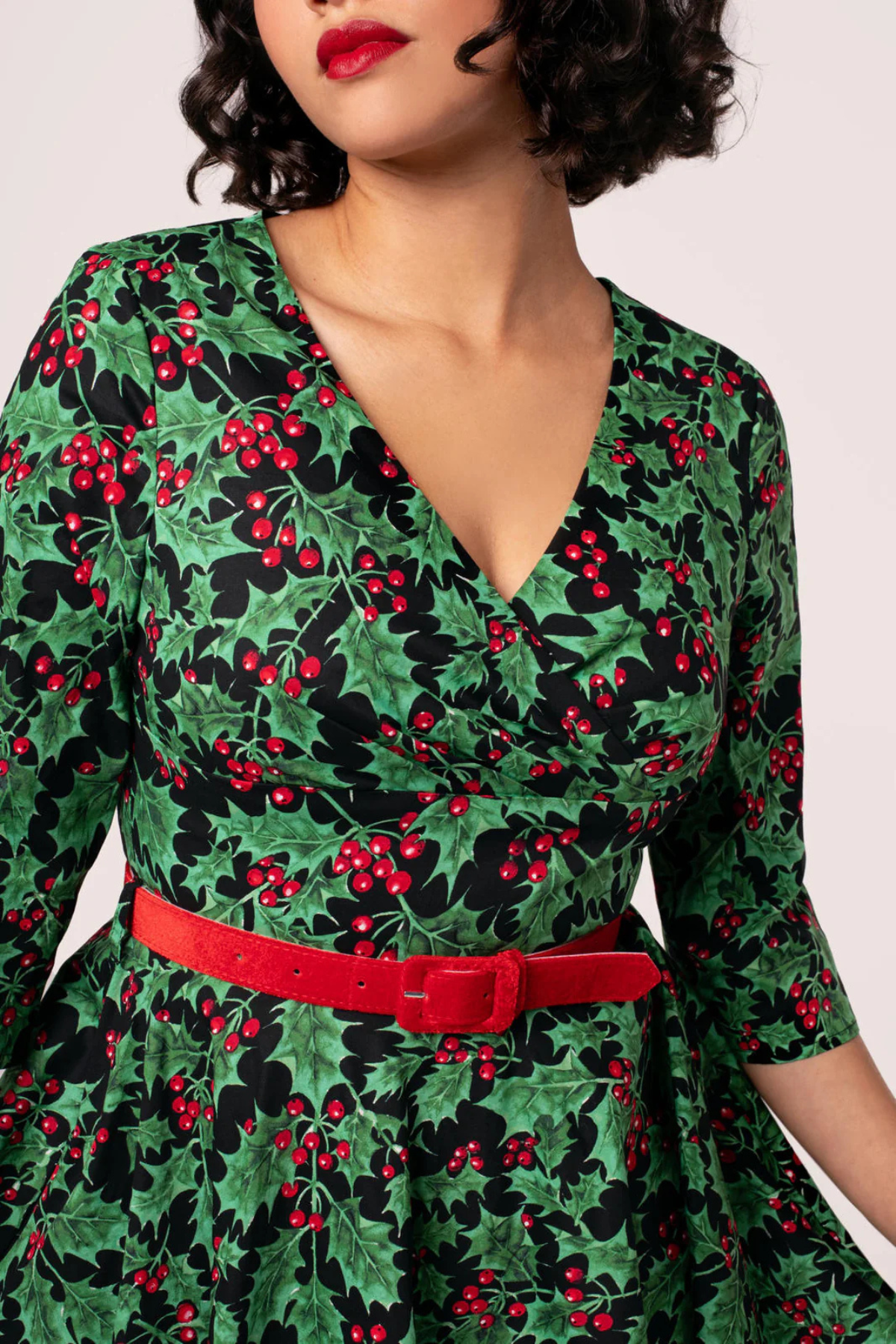 Detalje af Hell Bunny Nicole Dress – v-udskæring og rødt bælte med kristtornmønster