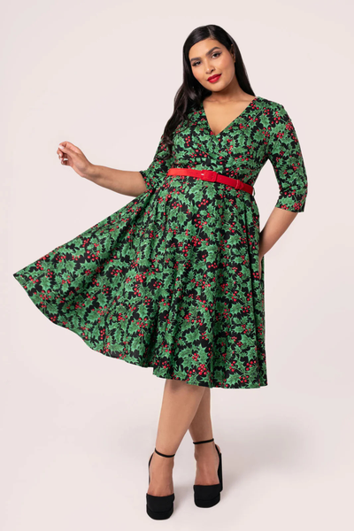 Hell Bunny Nicole Dress vist i bevægelse – grøn kjole med vintage holly print og rød velourbælte