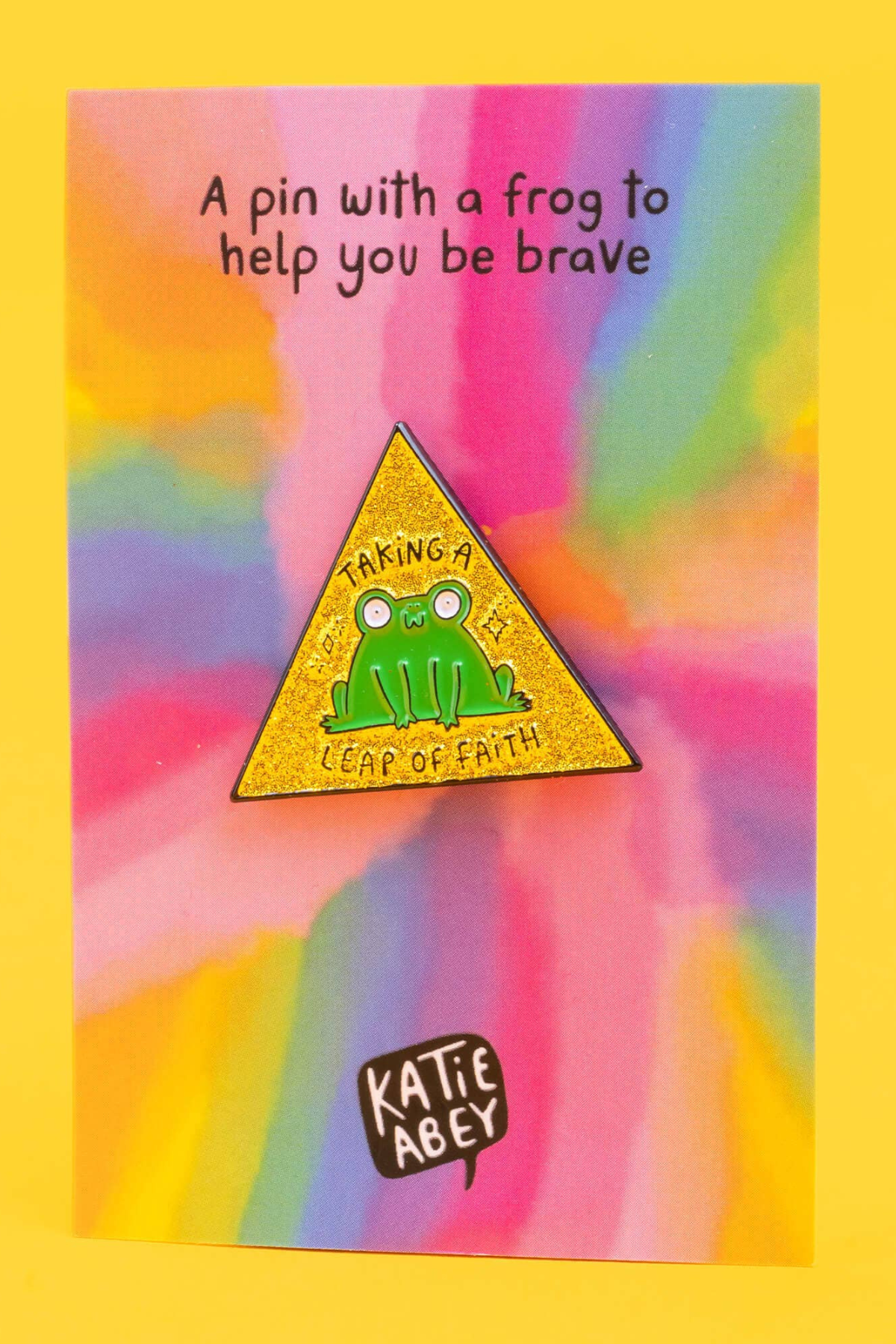Frø emaljepin monteret på farverigt tie-dye backing-card med teksten ‘A pin with a frog to help you be brave’