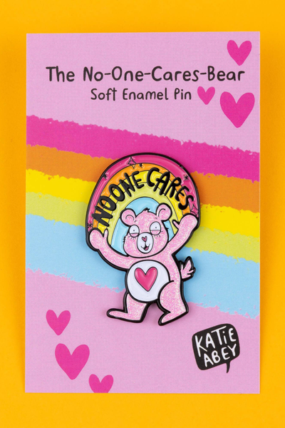 Katie Abey enamel pin monteret på farverigt backing card med regnbuestriber og hjerter