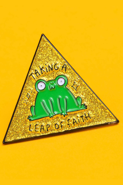 “Taking a Leap of Faith” frø emaljepin i gylden glitter trekant på gul baggrund