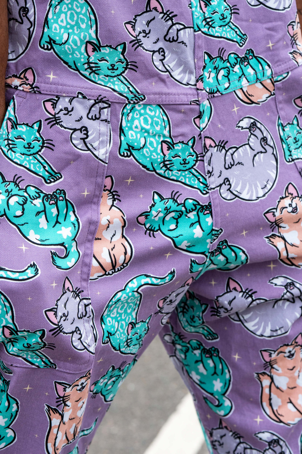 Close-up af katteprint på stretch twill stof i lilla nuancer