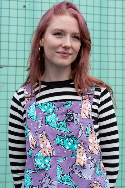 Nærbillede af print med farverige katte på lilla baggrund