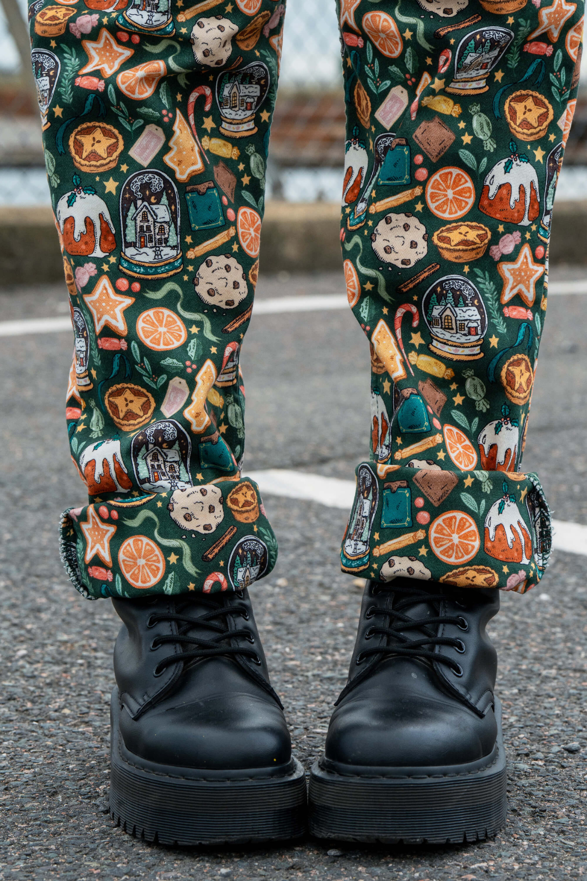 Oprullede bukseben på Yuletide Treats dungarees – grøn stretch-twill med julemotiver.