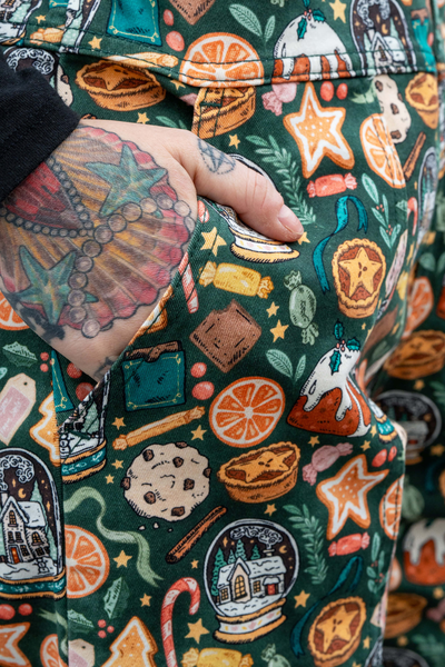 Hånd i sidelomme – close-up af juleprintet med stjerne-småkager og kandiserede appelsiner.