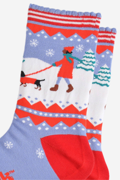 Nærbillede af mønster med kvinde, pølsehund og sne på bambusstrømper