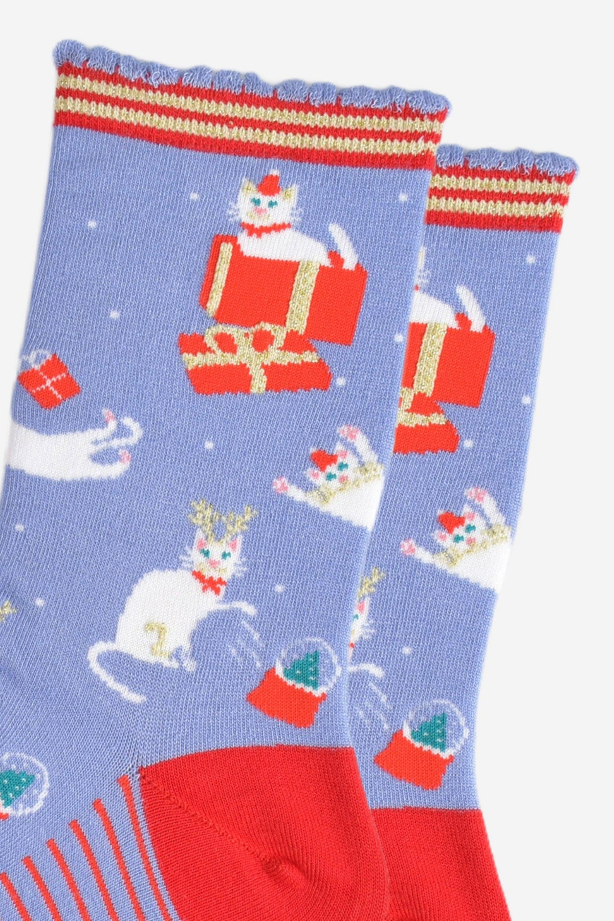 Nærbillede af julekat-design med gaveæske og snefnug på blå bambusstrømper