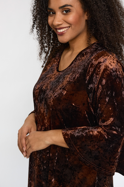 Nærbillede af STUDIO Helda Velourkjolens overdel og trompetærme.