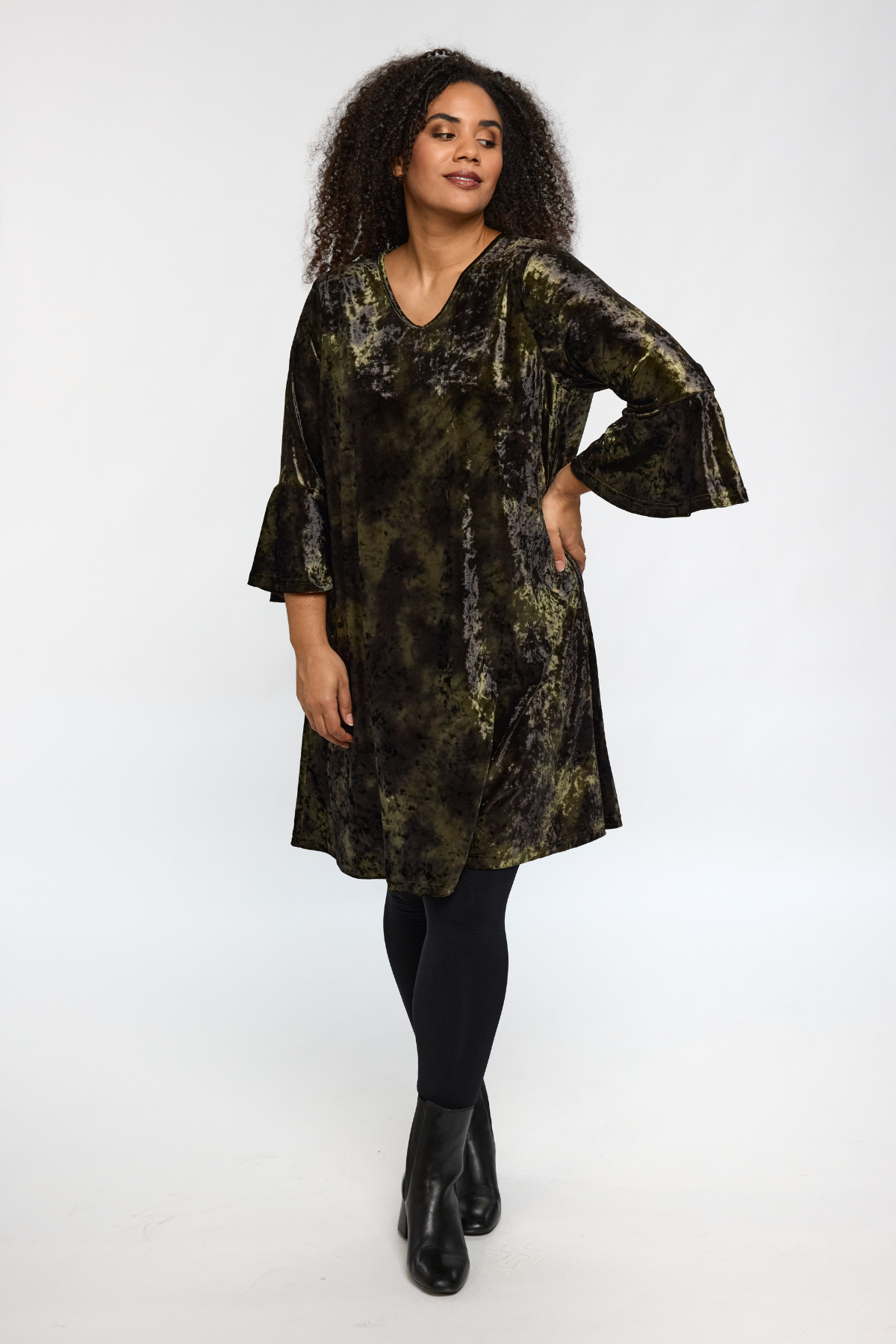 Model iført STUDIO Helda Velourkjole i grøn velour, set forfra.