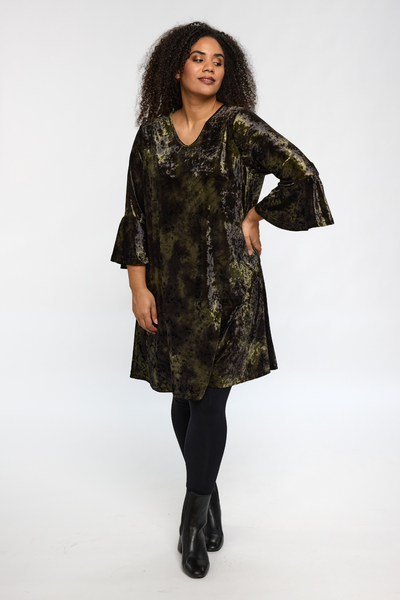 Model iført STUDIO Helda Velourkjole i grøn velour, set forfra.