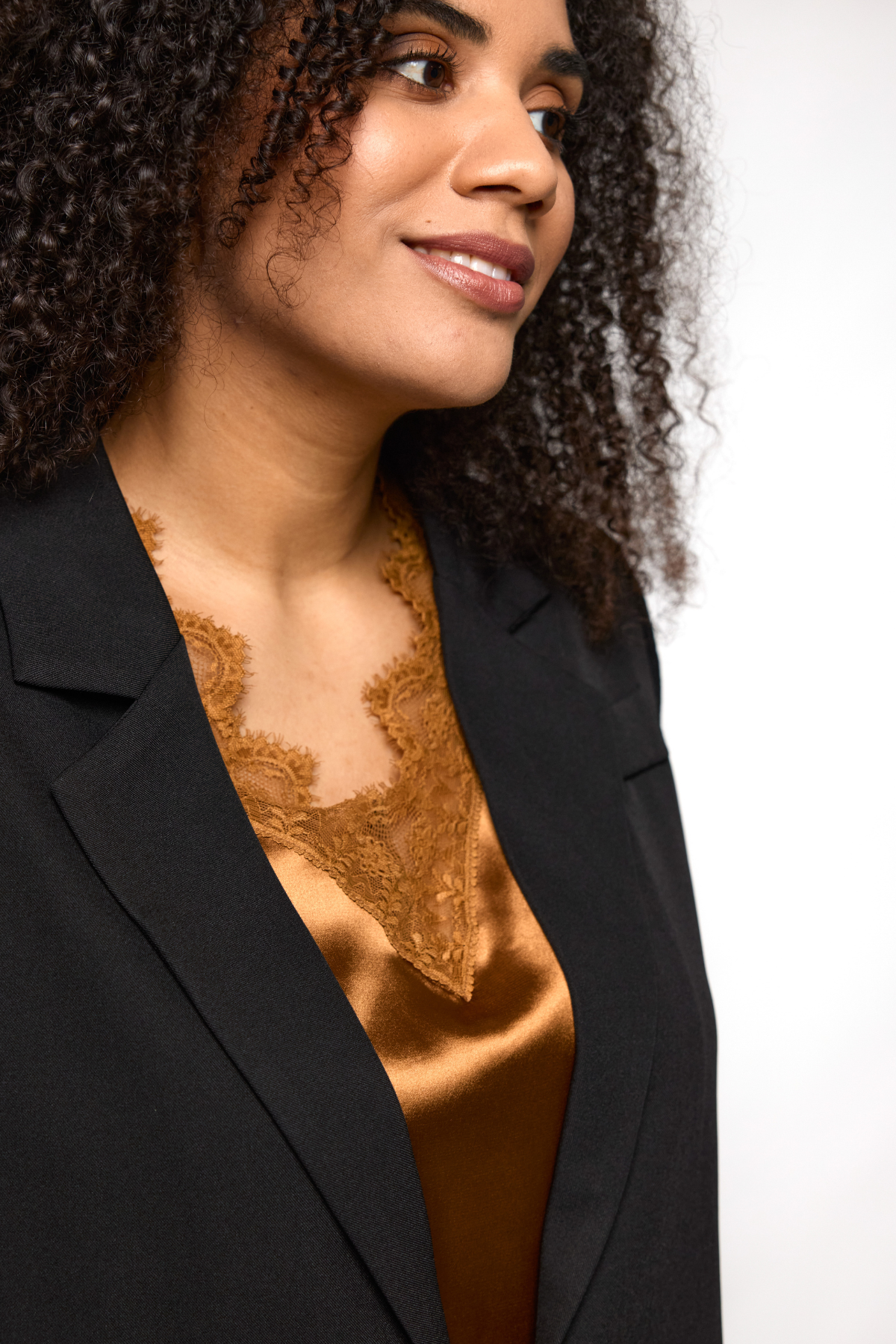 Nærbillede af blondekant og satinfinish på Ingrid top i kobber fra STUDIO.