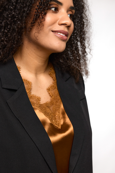 Nærbillede af blondekant og satinfinish på Ingrid top i kobber fra STUDIO.