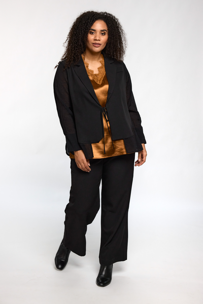 Model viser fuldt outfit med Ingrid top i kobber fra STUDIO stylet med sorte bukser.